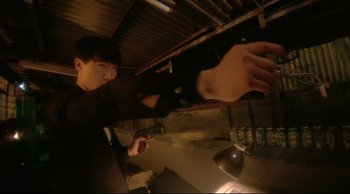 Movie still from “Fallen Angels” (1995), directed by Kar-Wai Wong – A man standing in front of an oven holding a light bulb; Medium shot, Low angle