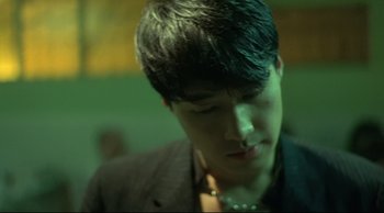 Movie still from “Fallen Angels” (1995), directed by Kar-Wai Wong – A young man with short black hair wearing a black jacket; Close Up shot, Low angle