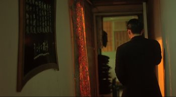 Movie still from “Fallen Angels” (1995), directed by Kar-Wai Wong – A man standing in front of a wall with stained glass; Medium shot, Over the shoulder angle