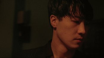 Movie still from “Fallen Angels” (1995), directed by Kar-Wai Wong – A man's face in a dark room; Extreme Close Up shot, Low angle