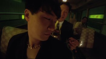 Movie still from “Fallen Angels” (1995), directed by Kar-Wai Wong – A man in a suit and tie holding a fork; Close Up shot, Low angle