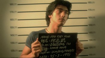 Movie still from “Fallen Angels” (1995), directed by Kar-Wai Wong – A man holding up a sign in front of a wall; Close Up shot, Low angle
