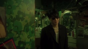 Movie still from “Fallen Angels” (1995), directed by Kar-Wai Wong – A man in a suit and sunglasses in a room; Medium shot, Low angle