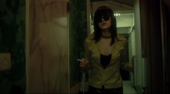 Movie still from “Fallen Angels” (1995), directed by Kar-Wai Wong – A woman in a yellow jacket smoking a cigarette; Medium shot, Low angle