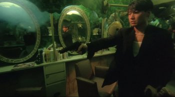 Movie still from “Fallen Angels” (1995), directed by Kar-Wai Wong – A man standing in front of a mirror in a dressing room; Medium shot, Low angle