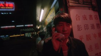 Movie still from “Fallen Angels” (1995), directed by Kar-Wai Wong – A man talking on a cell phone while standing on the street; Close Up shot, Low angle