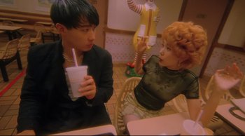 Movie still from “Fallen Angels” (1995), directed by Kar-Wai Wong – A man and a woman sitting at a table with a drink; Medium shot, High angle