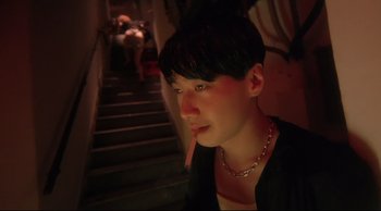 Movie still from “Fallen Angels” (1995), directed by Kar-Wai Wong – A woman with a cigarette in her mouth sitting on a chair; Close Up shot, High angle