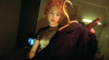 Movie still from “Fallen Angels” (1995), directed by Kar-Wai Wong – A woman with red hair holding an umbrella in a room; Close Up shot, Low angle