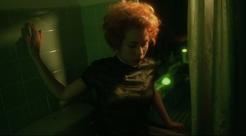 Movie still from “Fallen Angels” (1995), directed by Kar-Wai Wong – A woman with red curly hair standing next to a tiled wall; Medium shot, High angle