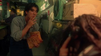 Movie still from “Fallen Angels” (1995), directed by Kar-Wai Wong – A man is smoking a cigarette in front of a woman; Medium shot, Low angle