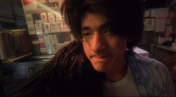 Movie still from “Fallen Angels” (1995), directed by Kar-Wai Wong – A man with dreadlocks is looking at the camera; Close Up shot, High angle