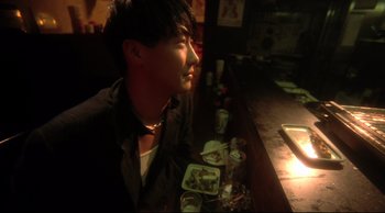 Movie still from “Fallen Angels” (1995), directed by Kar-Wai Wong – A man sitting at a counter in front of food; Close Up shot, High angle