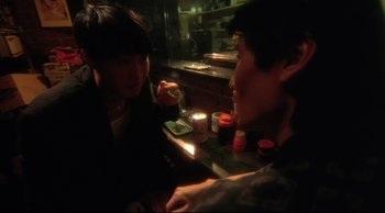 Movie still from “Fallen Angels” (1995), directed by Kar-Wai Wong – Two people sitting at a table with a candle; Close Up shot, High angle