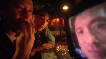 Movie still from “Fallen Angels” (1995), directed by Kar-Wai Wong – Two men sitting in front of a television in a bar; Extreme Close Up shot, High angle