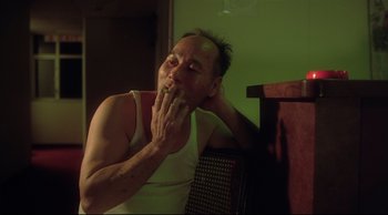 Movie still from “Fallen Angels” (1995), directed by Kar-Wai Wong – A man sitting on a chair with his hand on his face; Close Up shot, Low angle