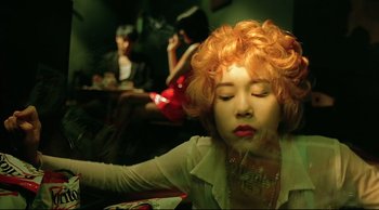 Movie still from “Fallen Angels” (1995), directed by Kar-Wai Wong – A woman with red curly hair and red lipstick; Close Up shot, Low angle