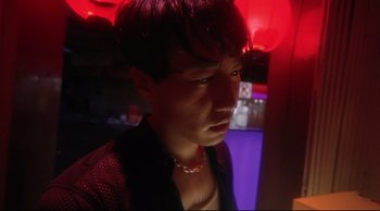 Movie still from “Fallen Angels” (1995), directed by Kar-Wai Wong – A young man in a black shirt and a red necklace; Close Up shot, Low angle