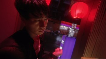 Movie still from “Fallen Angels” (1995), directed by Kar-Wai Wong – A man in a red shirt and black jacket is standing in a room; Close Up shot, Low angle