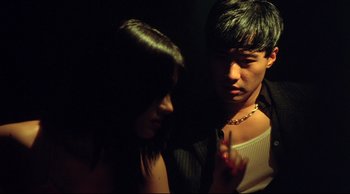 Movie still from “Fallen Angels” (1995), directed by Kar-Wai Wong – A man and a woman standing next to each other in the dark; Close Up shot, Low angle