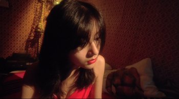 Movie still from “Fallen Angels” (1995), directed by Kar-Wai Wong – A woman in a red dress sitting on a bed; Close Up shot, High angle