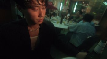 Movie still from “Fallen Angels” (1995), directed by Kar-Wai Wong – A woman sitting in front of a group of diners at a restaurant; Close Up shot, Low angle