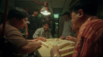 Movie still from “Fallen Angels” (1995), directed by Kar-Wai Wong – A group of people playing a game of mahjong; Medium shot, High angle