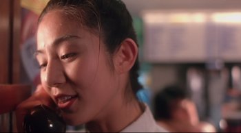 Movie still from “Fallen Angels” (1995), directed by Kar-Wai Wong – A person smiling with her eyes closed; Close Up shot, Low angle