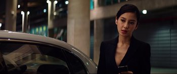 Movie still from “Hitman: Agent 47” (2015), directed by Aleksander Bach – A woman standing next to a car holding a cell phone; Close Up shot, Over the shoulder angle