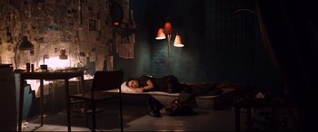 Movie still from “Hitman: Agent 47” (2015), directed by Aleksander Bach – A woman laying on a bed in a dark room; Wide shot, High angle