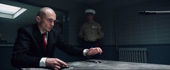 Movie still from “Hitman: Agent 47” (2015), directed by Aleksander Bach – A man in a black suit and white shirt and a man in a black suit and white shirt; Medium shot, Low angle