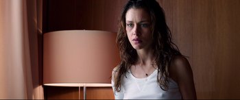 Movie still from “Hitman: Agent 47” (2015), directed by Aleksander Bach – A young woman with long brown curly hair wearing a white shirt; Close Up shot, Low angle
