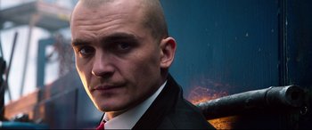 Movie still from “Hitman: Agent 47” (2015), directed by Aleksander Bach – A man in a black suit and a red tie; Close Up shot, Low angle