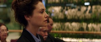 Movie still from “Hitman: Agent 47” (2015), directed by Aleksander Bach – A woman in a business suit looking to her left; Close Up shot, Over the shoulder angle