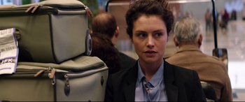 Movie still from “Hitman: Agent 47” (2015), directed by Aleksander Bach – A woman in a suit and tie next to a suitcase; Close Up shot, Over the shoulder angle