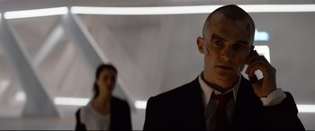 Movie still from “Hitman: Agent 47” (2015), directed by Aleksander Bach – A man in a black suit and a woman in a red tie; Close Up shot, Low angle