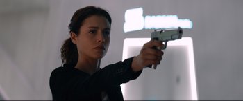 Movie still from “Hitman: Agent 47” (2015), directed by Aleksander Bach – A woman is holding a gun in her hand; Close Up shot, Over the shoulder angle