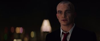 Movie still from “Hitman: Agent 47” (2015), directed by Aleksander Bach – A man in a suit and red tie; Close Up shot, Over the shoulder angle