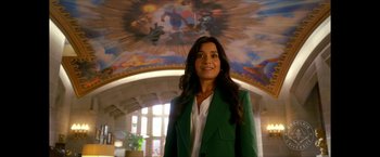 Movie still from “Gen V” (2023), created by Eric Kripke – A woman in a green jacket standing in a room; Medium shot, Low angle