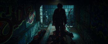 Movie still from “Gen V” (2023), created by Eric Kripke – A man standing in a room with a bunch of trash; Wide shot, Low angle