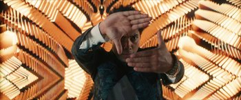 Movie still from “Gen V” (2023), created by Eric Kripke – A man holding his hands up in front of his face; Medium shot, Low angle