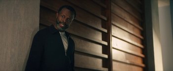 Movie still from “Gen V” (2023), created by Eric Kripke – A man standing in front of a wooden wall; Medium shot, Low angle