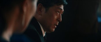 Movie still from “Gen V” (2023), created by Eric Kripke – A person wearing a suit and tie; Close Up shot, Over the shoulder angle