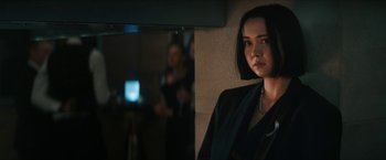 Movie still from “Gen V” (2023), created by Eric Kripke – A woman in a black jacket is standing in front of a mirror; Close Up shot, Over the shoulder angle