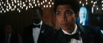 Movie still from “Gen V” (2023), created by Eric Kripke – A man in a suit and tie looking at the camera; Close Up shot, Over the shoulder angle