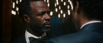 Movie still from “Gen V” (2023), created by Eric Kripke – A person wearing a suit and bow tie; Close Up shot, Over the shoulder angle