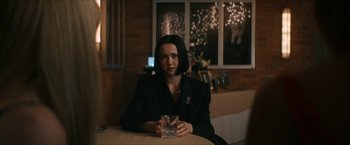 Movie still from “Gen V” (2023), created by Eric Kripke – A woman sitting at a table holding a glass of wine; Medium shot, Over the shoulder angle