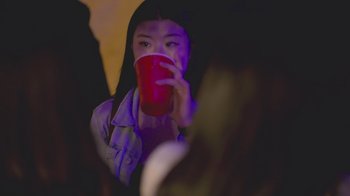 Movie still from “Homeroom” (2021), directed by Peter Nicks – A woman holding a red cup in her hand; Close Up shot, Over the shoulder angle