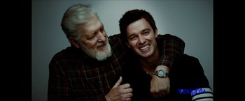 Movie still from “Gen V” (2023), created by Eric Kripke – A man and an older man smiling for the camera; Close Up shot, Low angle