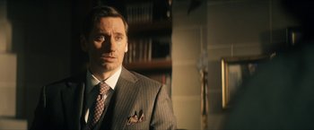 Movie still from “Gen V” (2023), created by Eric Kripke – A man in a suit and tie; Close Up shot, Over the shoulder angle